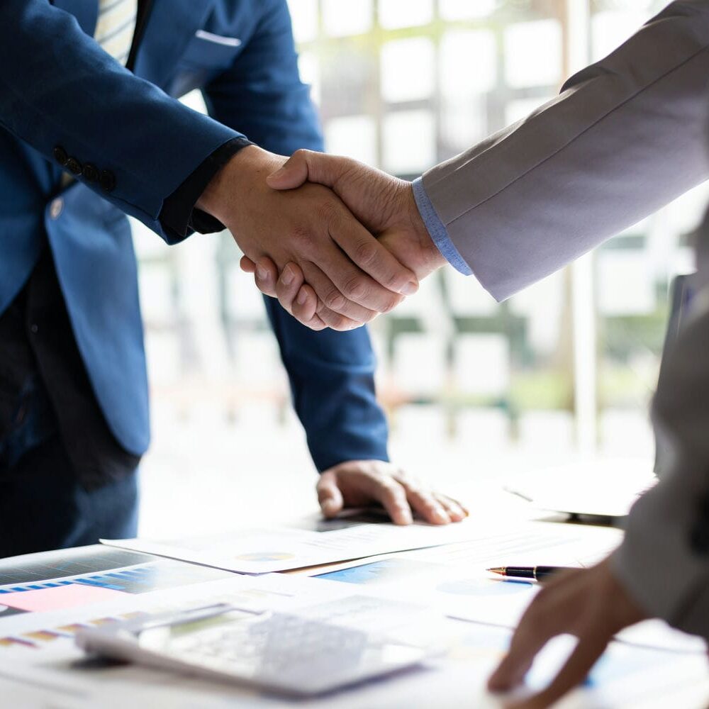 Business professionals shaking hands during a Toronto REIT investment partnership discussion